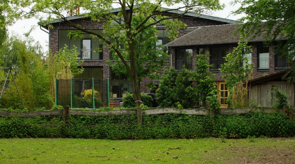 a house with a fence in front of a yard at Gästewohnung Hardinghaus am Teich in Warendorf