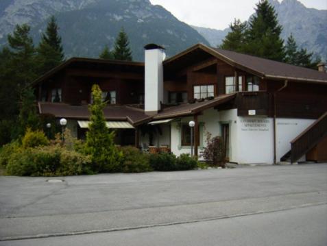 a large building with a mountain in the background at Landhaus Solaris in Leutasch