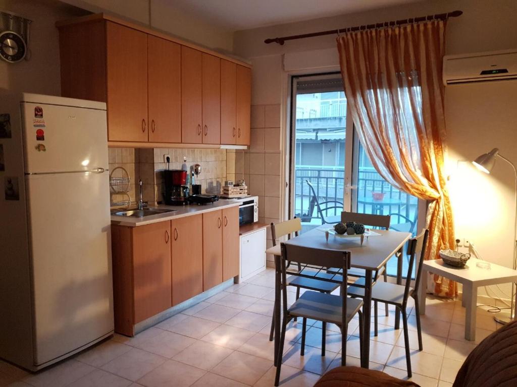 ペライアにあるNana Apartmentsのキッチン(白い冷蔵庫、テーブル、椅子付)