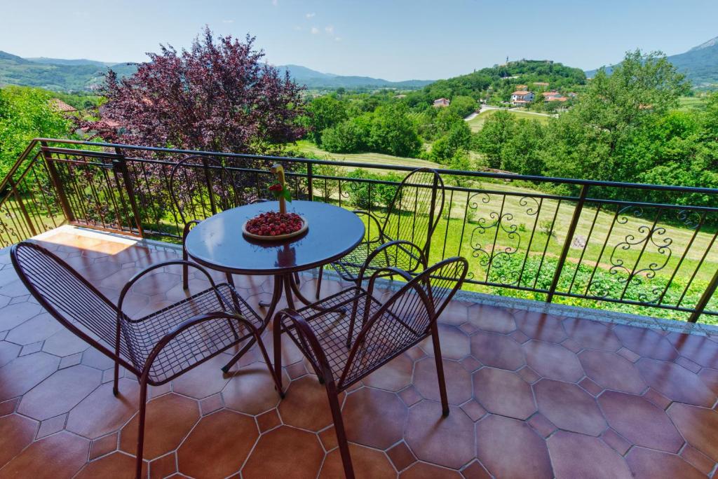 eine Terrasse mit einem Tisch und Stühlen auf dem Balkon in der Unterkunft Apartma Kapitanovše in Ajdovščina