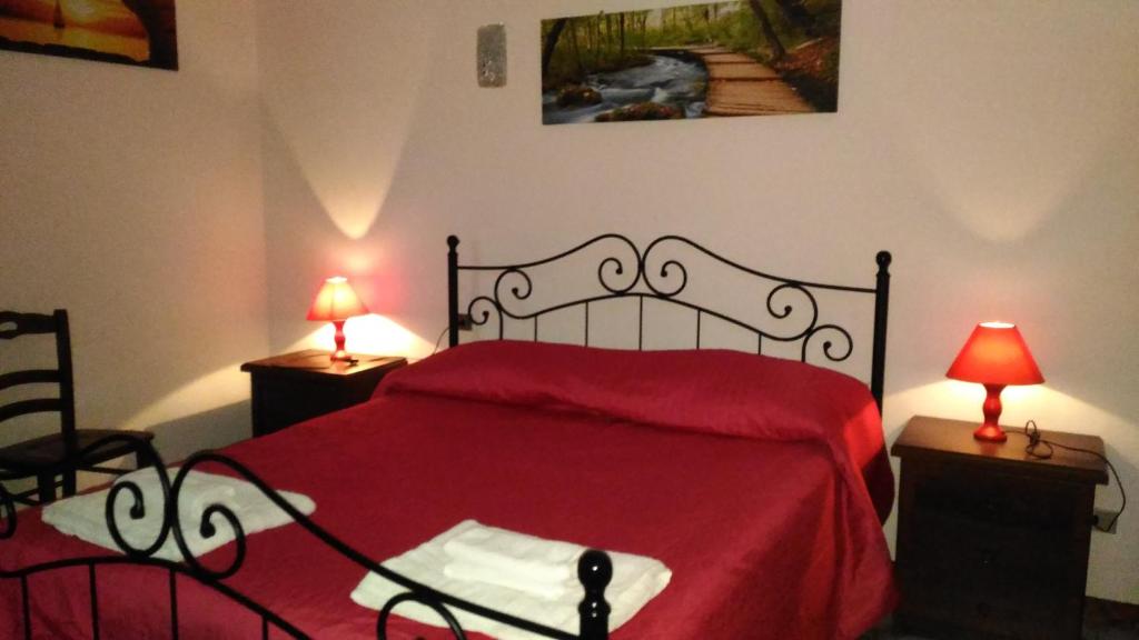 ミラッツォにあるHotel Californiaのベッドルーム1室(赤いベッド1台、ランプ2つ付)