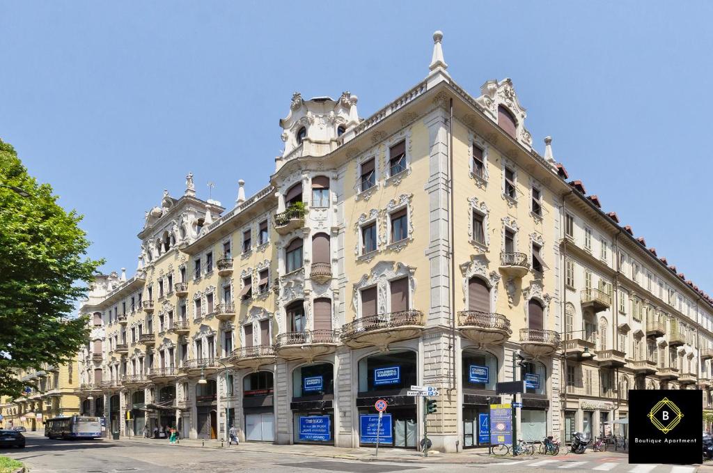 un gran edificio blanco en una calle de la ciudad en Boutique Apartment Glamour Torino, en Turín