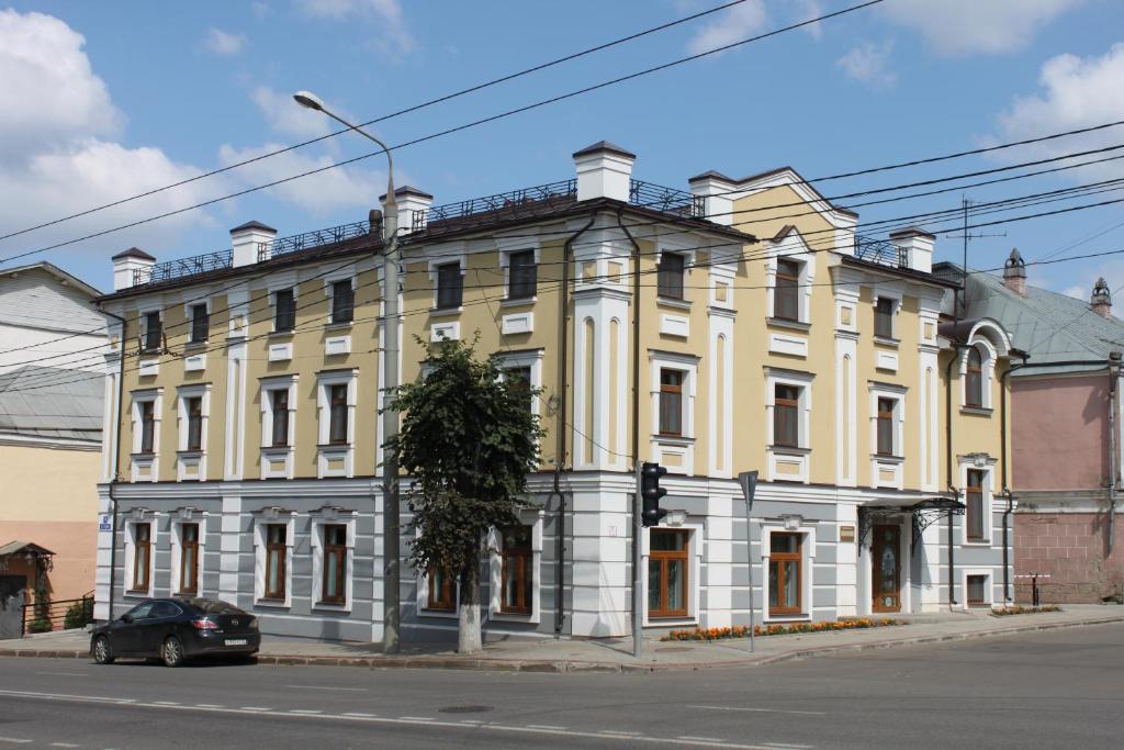 un edificio blanco y amarillo en la esquina de una calle en Rus Hotel en Vladimir