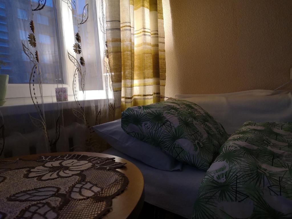 a room with a bed and a table and a window at DvīņuMājas Vintage B&B in Balvi