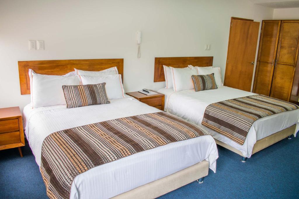 Postel nebo postele na pokoji v ubytování Hotel Estación Sabana