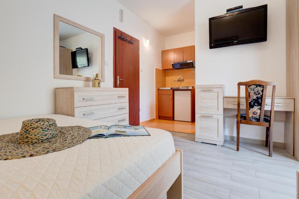 1 dormitorio con 1 cama y TV en la pared en Apartments Radojević, en Petrovac na Moru