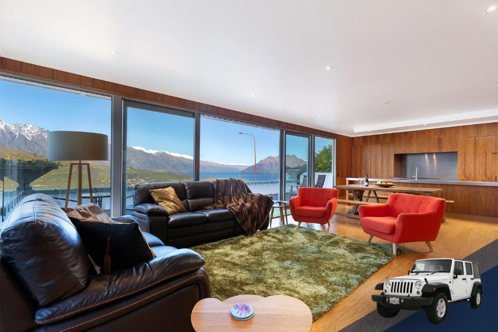 ein Wohnzimmer voller Möbel und einem großen Fenster in der Unterkunft Luxe Home on the Hill in Queenstown