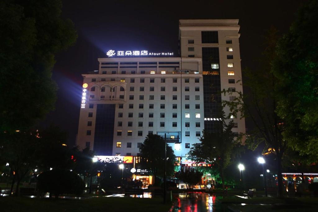 budynek z znakiem na górze w nocy w obiekcie Atour Hotel (Nantong Zhongcheng) w mieście Nantong
