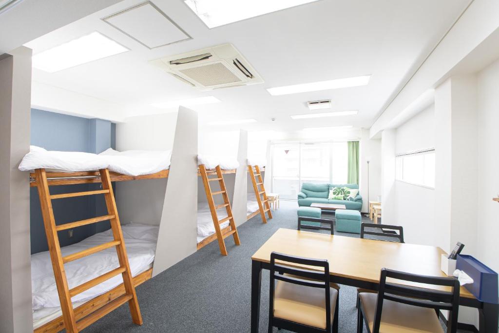 a room with bunk beds and a table and chairs at East End Building Central Osaka Apartments - Self Check-In Only in Osaka