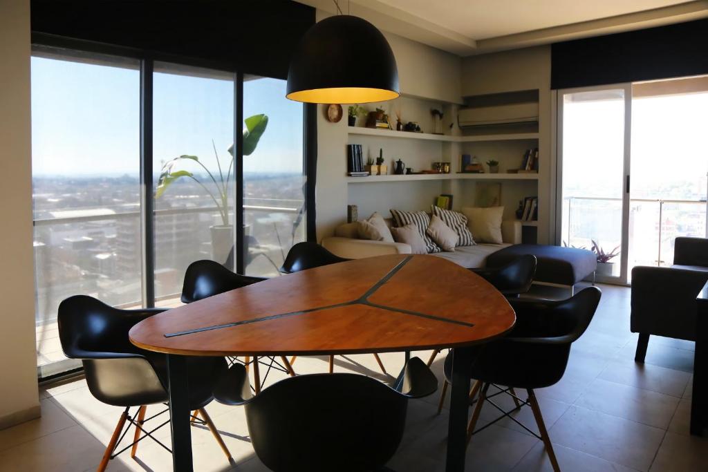 sala de estar con mesa, sillas y sofá en Garden Point Luxury Apartments en San Miguel de Tucumán
