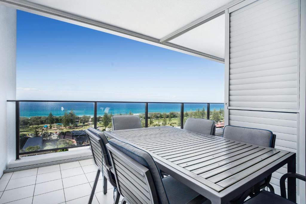 
a dining room table with a view of the ocean at Ultra Broadbeach in Gold Coast
