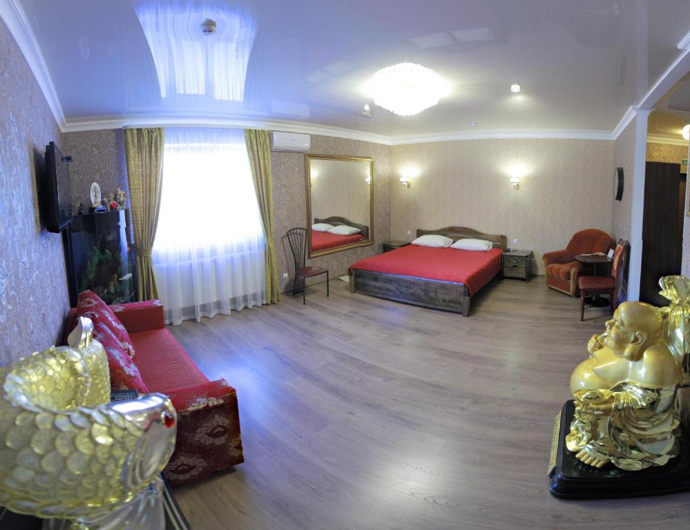 a room with a bedroom with a bed and a couch at Міні-готель Пекін in Mykolaiv