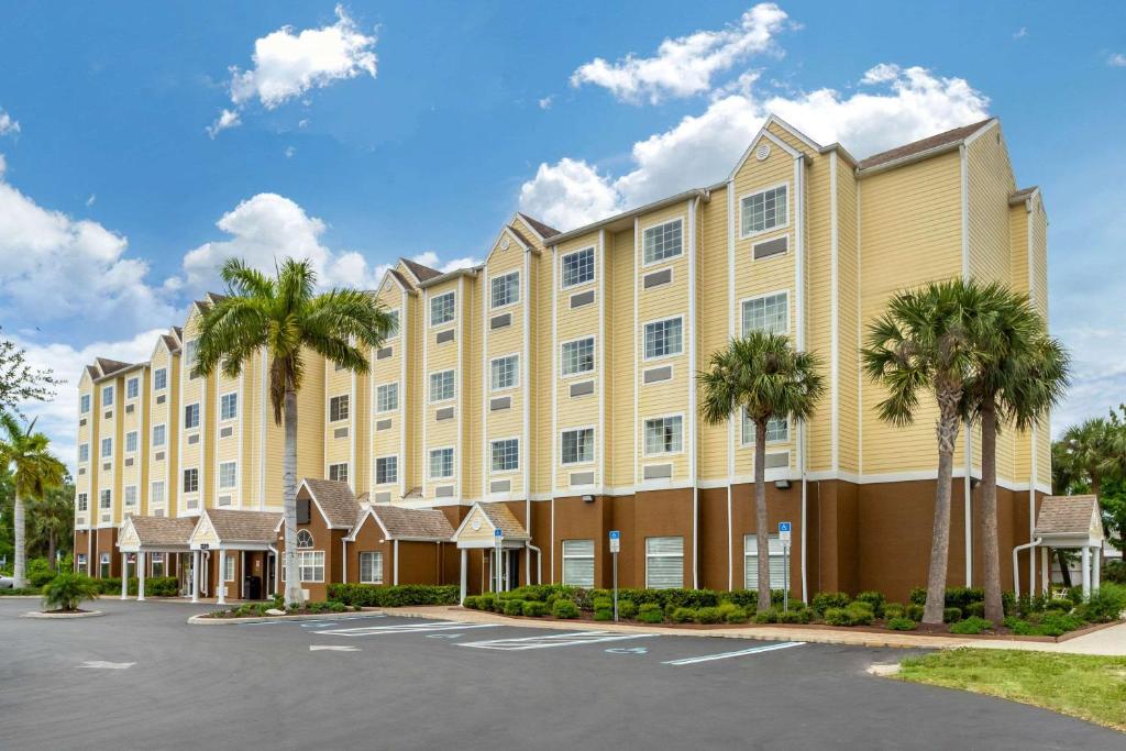 ein großes Gebäude mit Palmen auf einem Parkplatz in der Unterkunft Quality Inn & Suites Lehigh Acres Fort Myers in Lehigh Acres