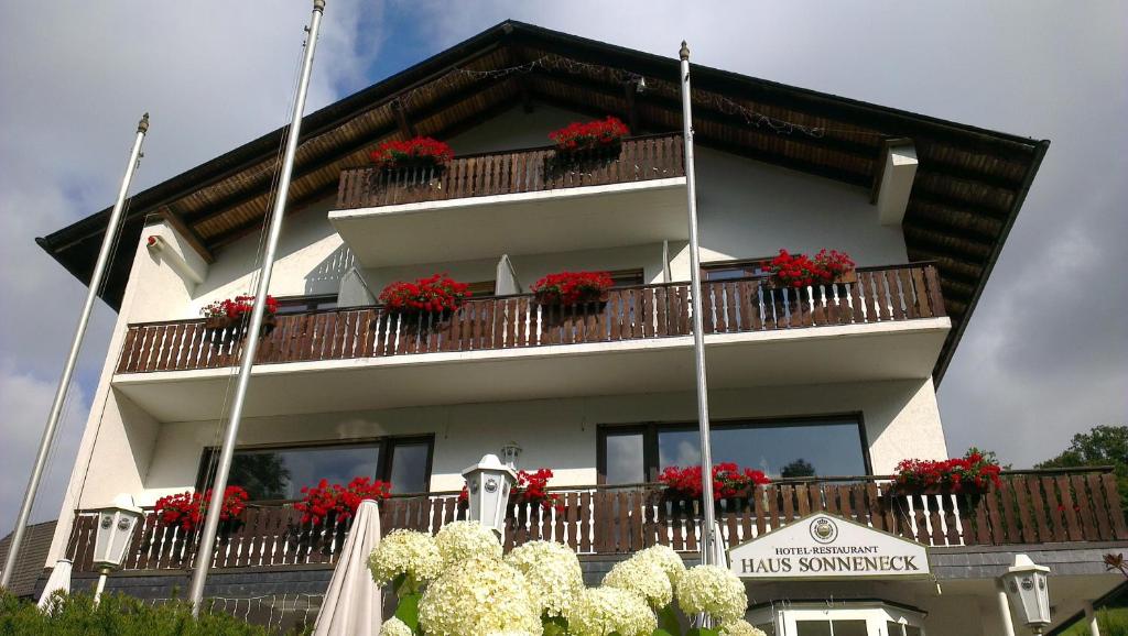 ein Gebäude mit roten Blumen auf den Balkonen in der Unterkunft Sonneneck in Winterberg