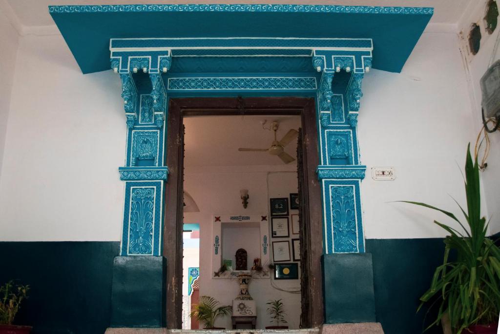 eine verzierte Tür in ein Zimmer mit blauem Rahmen in der Unterkunft Kings Retreat Jodhpur in Jodhpur