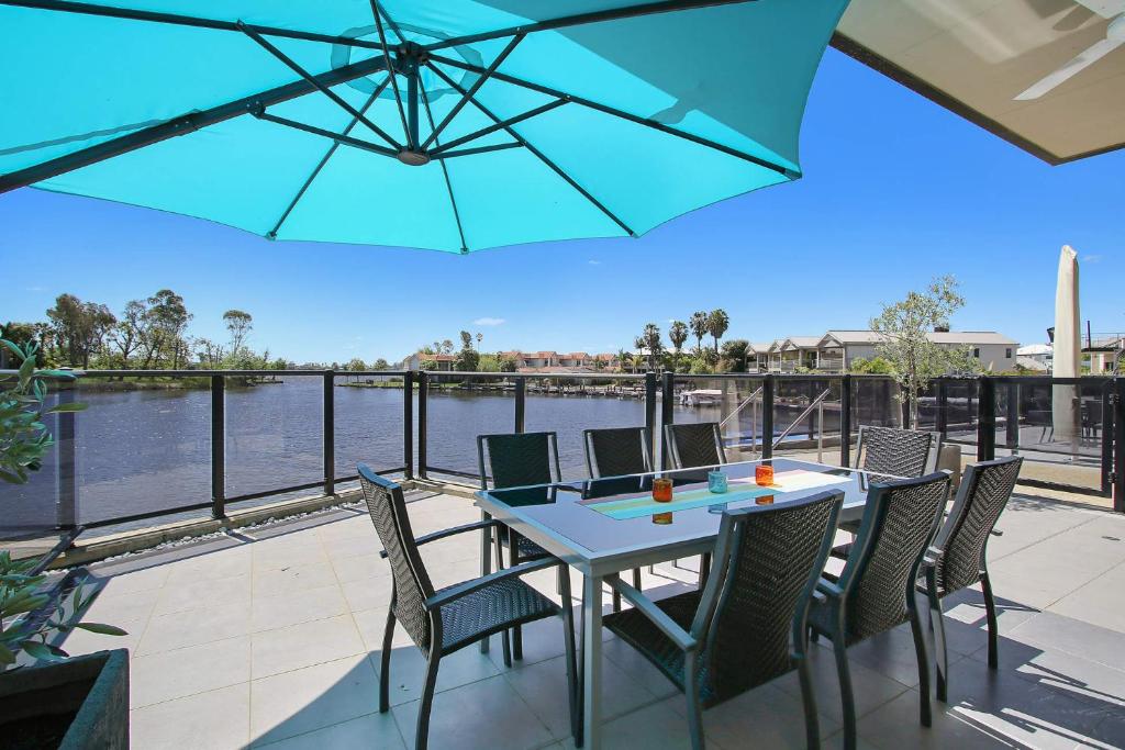 a patio with a table and chairs with a view of the water at Cypress Townhouse 11 in Mulwala