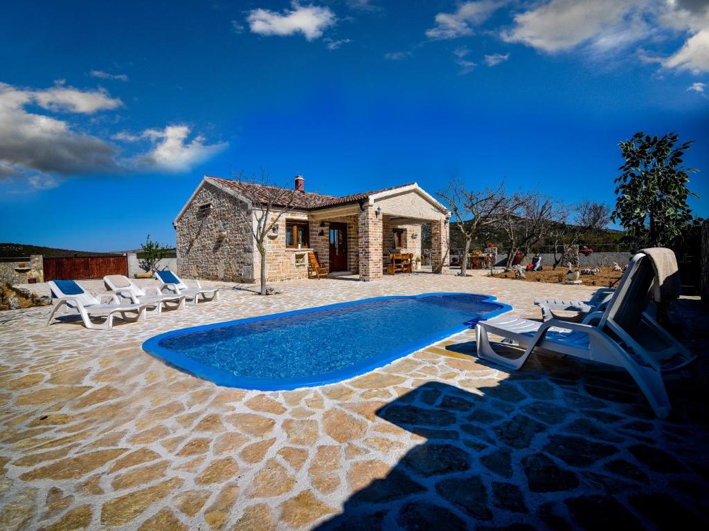 een groot blauw zwembad voor een huis bij Holiday home Anita 2 for 8 persons with pool in Stankovci