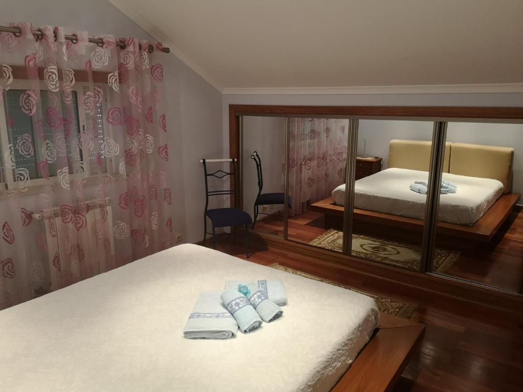 um quarto com duas camas e um espelho em Cantinho do Lucas em Alvaiázere