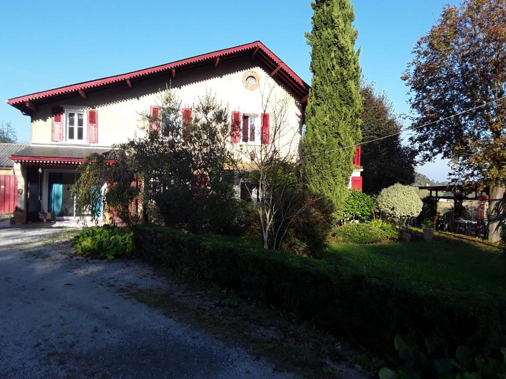 Maison blanche avec volets rouges dans une rue dans l'établissement Chez Cécile et Jean-No, à Gan