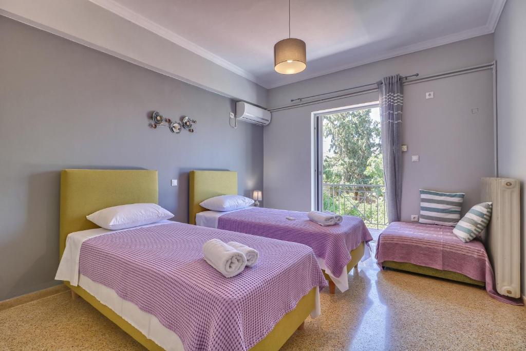 um quarto com 2 camas e uma janela em Carpe Diem near the Athens airport em Markopoulo Mesogaias