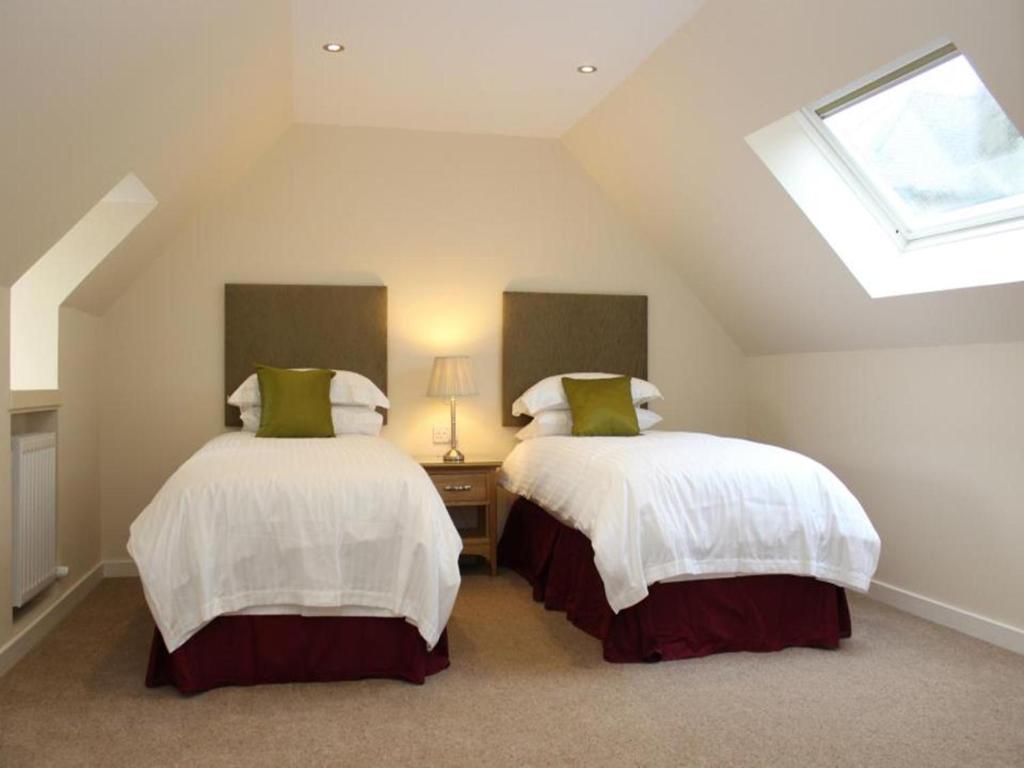 two beds in a attic room with a skylight at The Inn @ Y-Not in Thurso