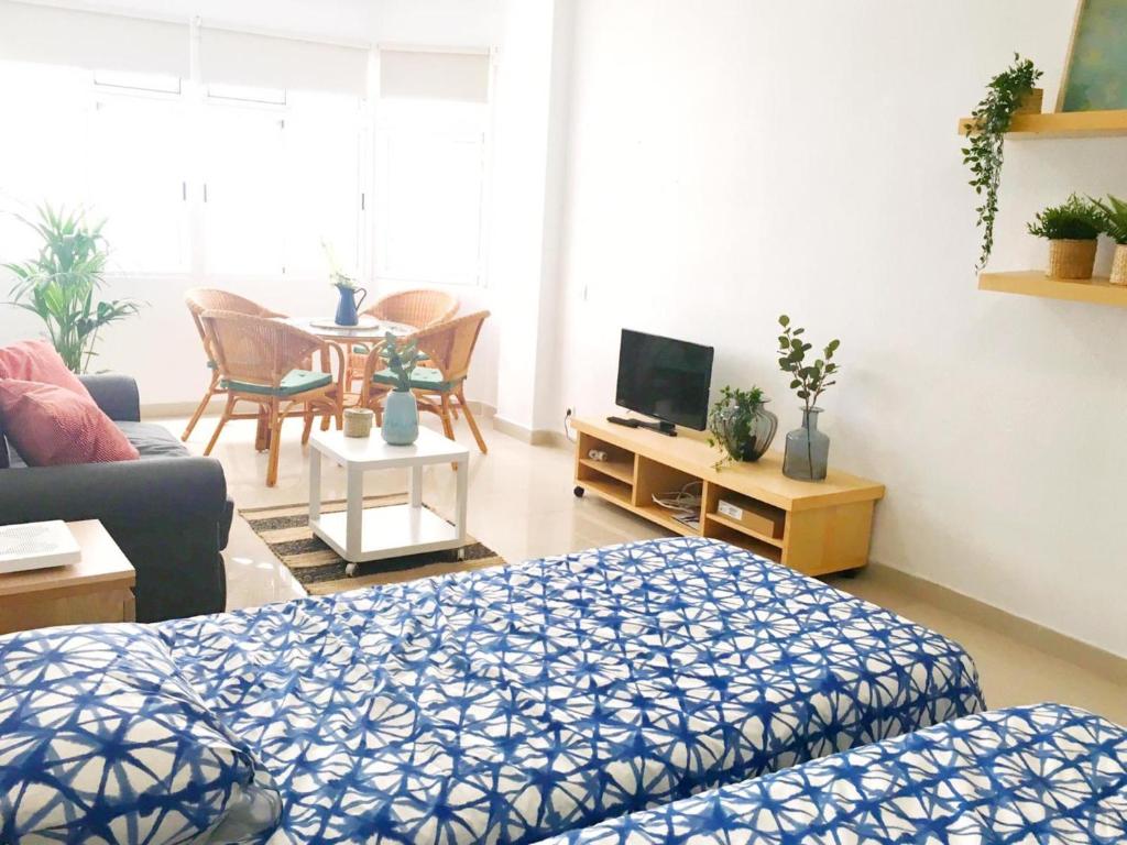sala de estar con cama, sofá y TV en Padre Cueto Beach Flat by Canary365, en Las Palmas de Gran Canaria