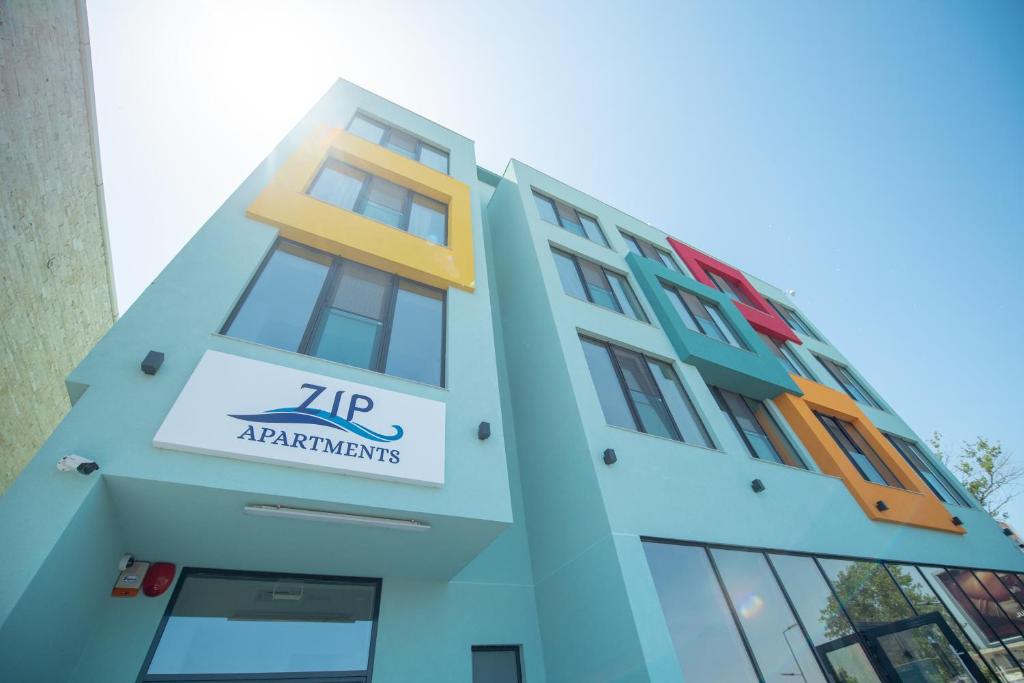 a building with a sign on the side of it at ZIP Apartments in Mamaia