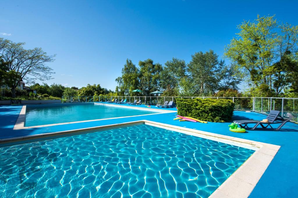 a large swimming pool with blue water at LE SOUFFLE VERT in Cussac