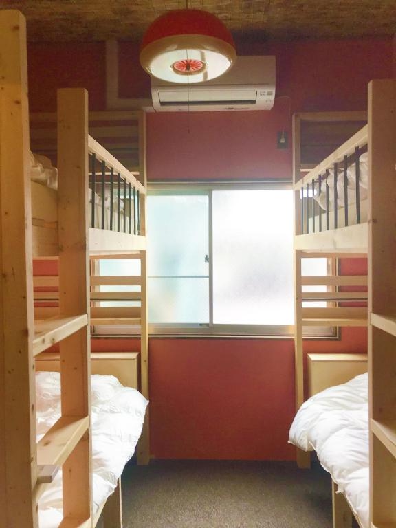 Postel nebo postele na pokoji v ubytování Mad Cat Hostel Osaka & Bar
