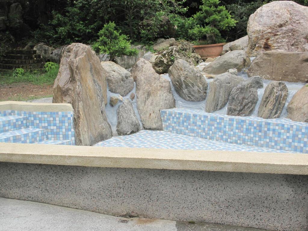 a stone bench with rocks in a garden at Green 58 B&amp;B in Hengchun South Gate
