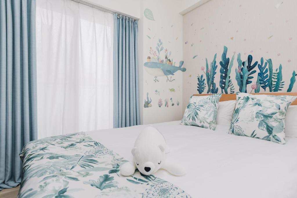 a bedroom with a white teddy bear sitting on a bed at AFP Tennoji Apartment in Osaka