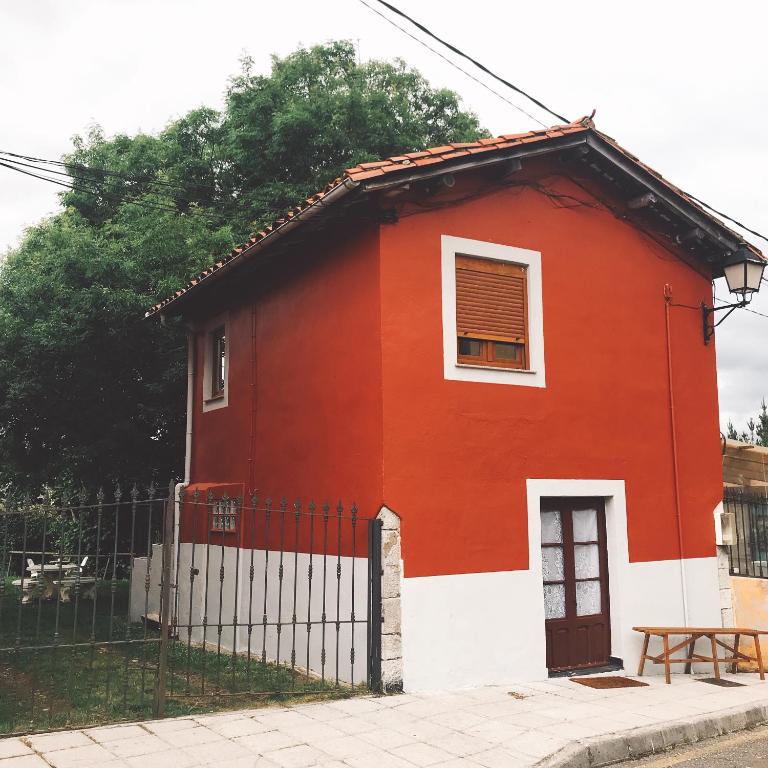a red and white house with a fence at La casina del Indiano in Malleza