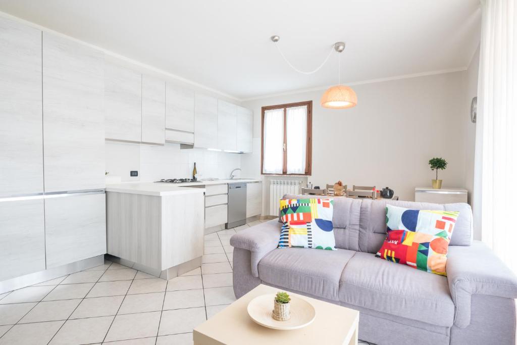 a living room with a couch and a kitchen at Gardappartamenti Sorgente Pool in Sirmione