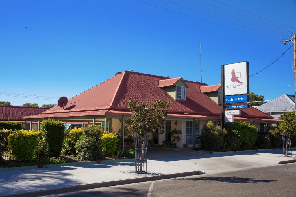 a building with a red roof on a street at Pioneer Motel Goondiwindi in Goondiwindi