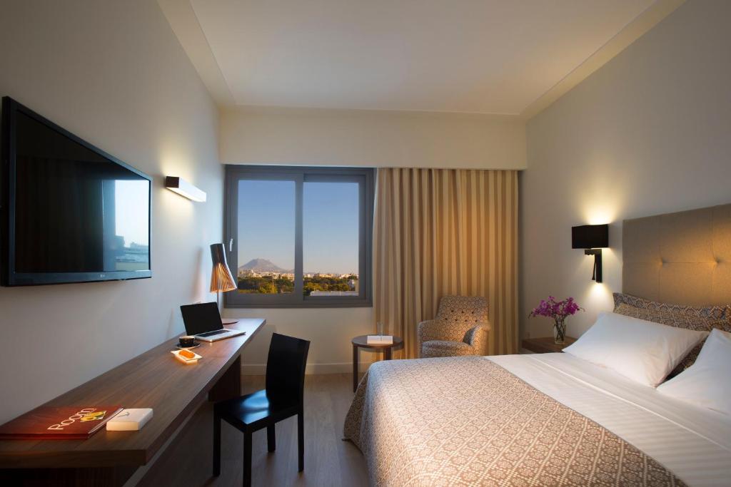 A bed or beds in a room at Aquila Atlantis Hotel