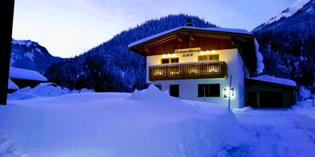 a snow covered building with a sign on it at Ferienwohnung Lech'tl in Steeg