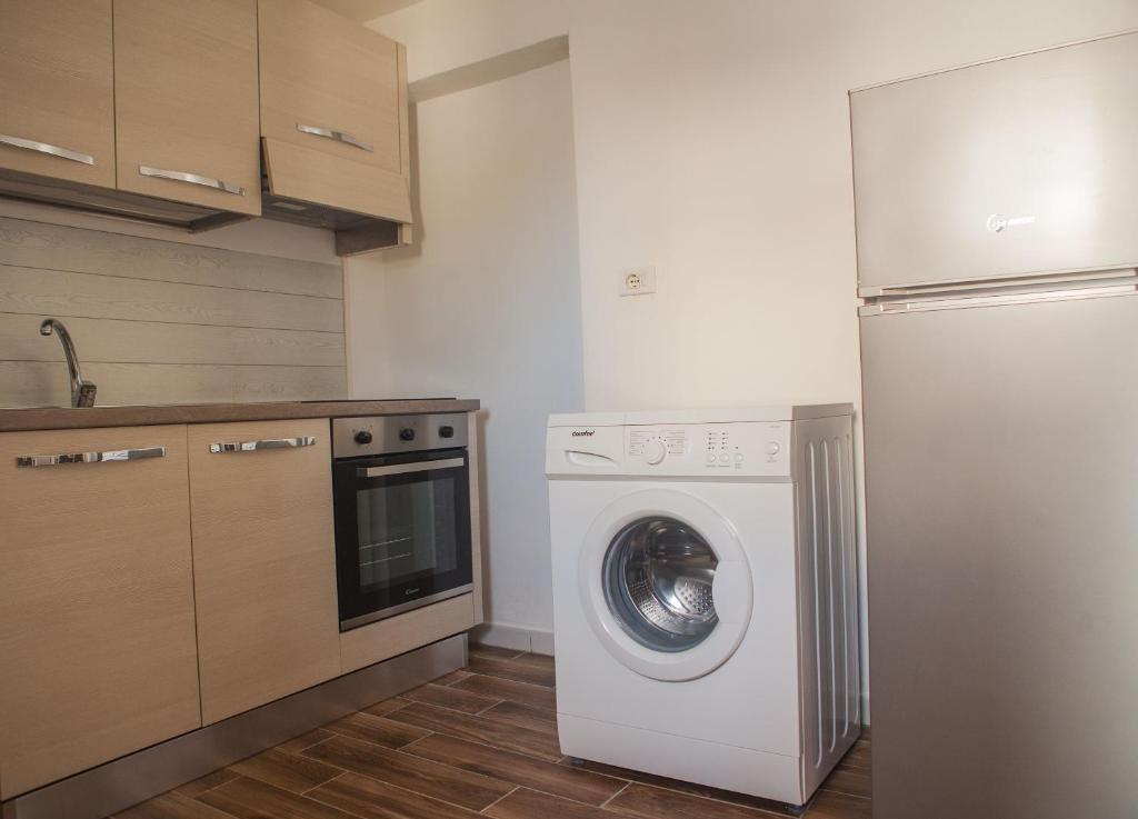 a kitchen with a washing machine and a refrigerator at La Bellavista Mola di Bari in Mola di Bari