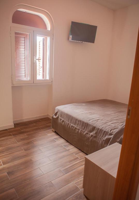 a small bedroom with a bed and a window at La Bellavista Mola di Bari in Mola di Bari