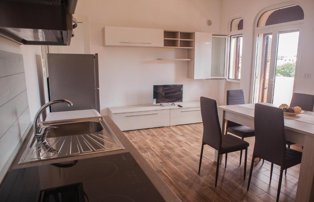 a kitchen with a sink and a table with chairs at La Bellavista Mola di Bari in Mola di Bari