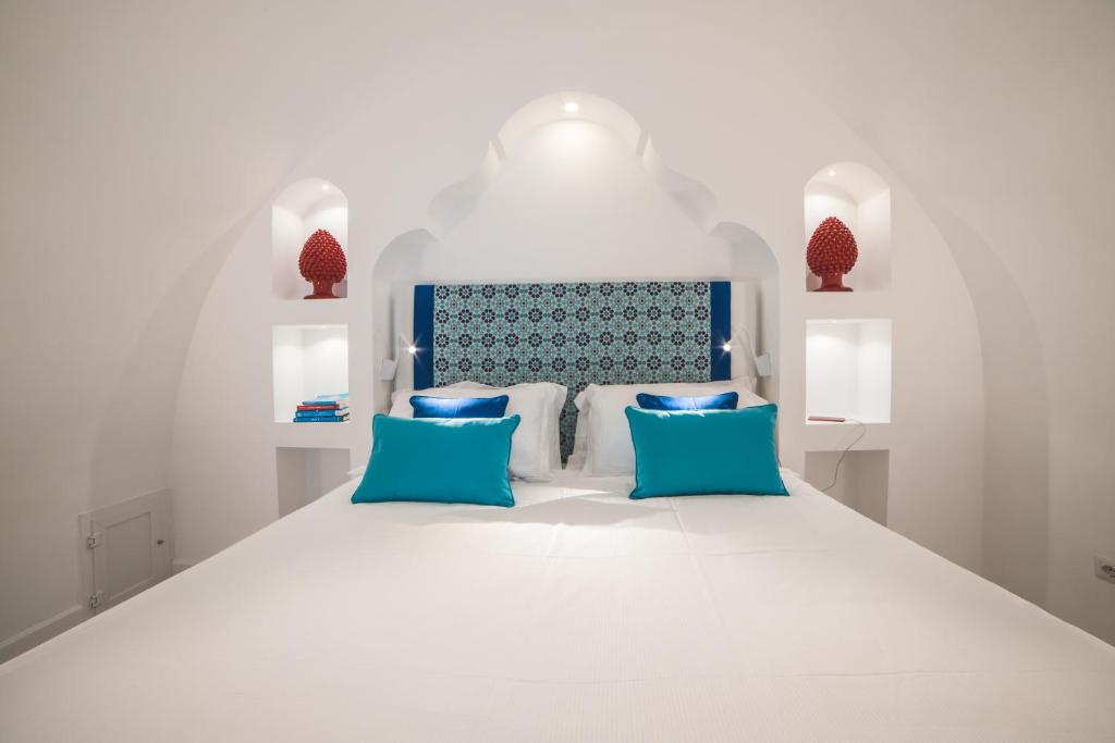 een slaapkamer met een wit bed met blauwe kussens bij Day Dream Sorrento in Sorrento