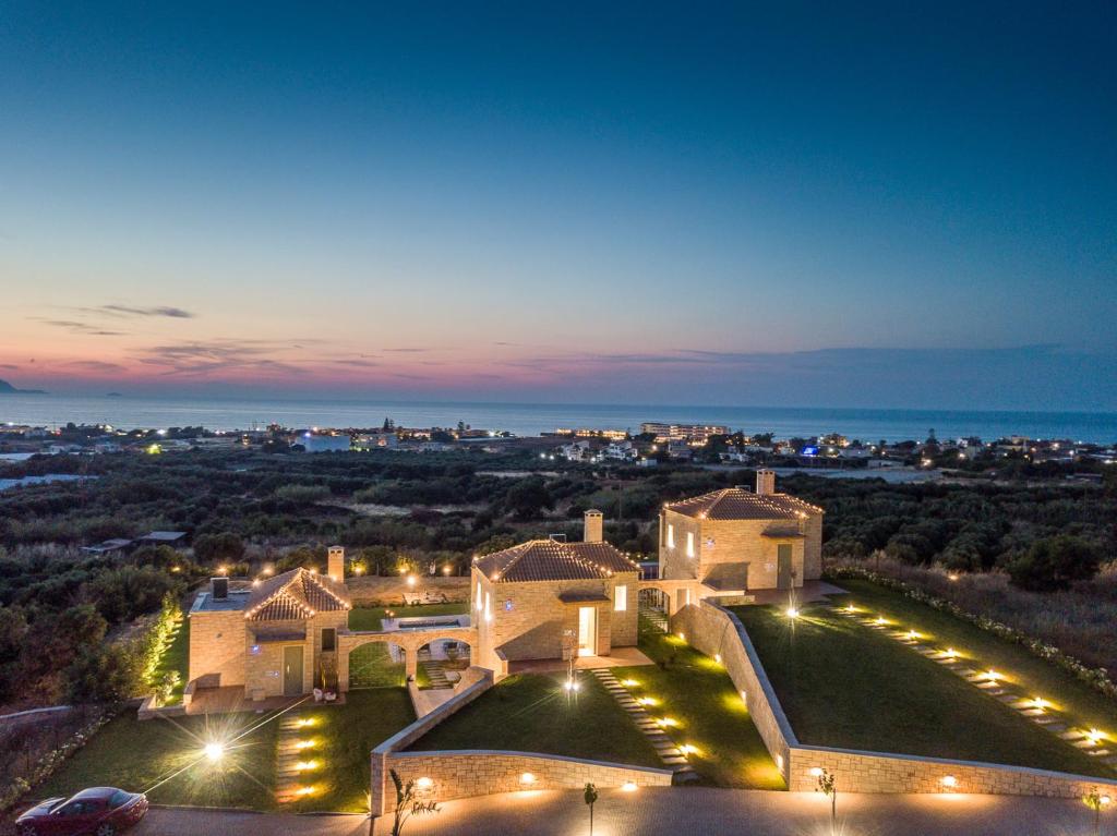 a view of a mansion at night with lights at Caldera Theros Villas in Hersonissos