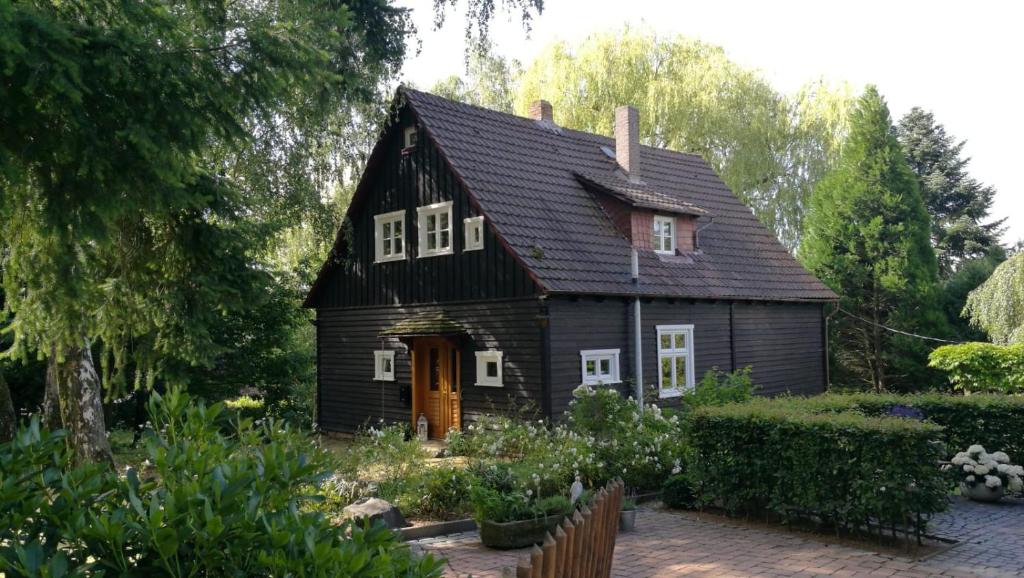 ein Schwarz-Weiß-Haus mit Garten in der Unterkunft "Haus am Knobben" in Uslar