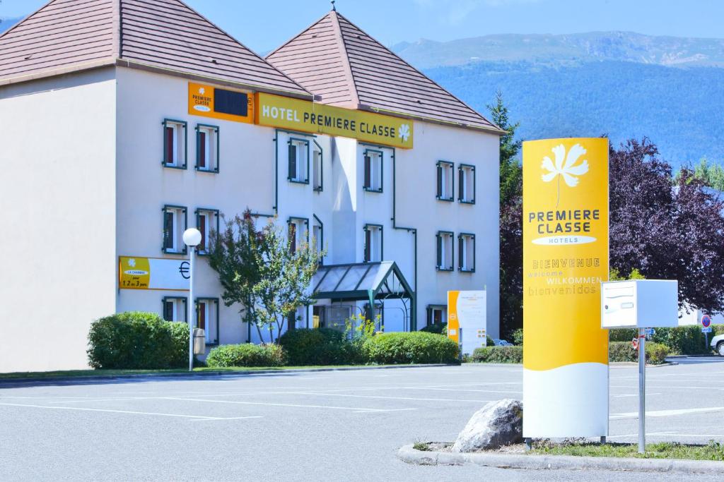 a building with a sign in front of it at Premiere Classe Geneve - Saint Genis Pouilly in Saint-Genis-Pouilly