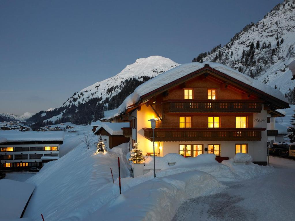 a house in the snow in front of a mountain at Pension Regina in Lech am Arlberg