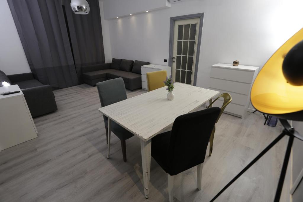- un salon avec une table et des chaises blanches dans l'établissement Central Panoramic Suite Rimini, à Rimini