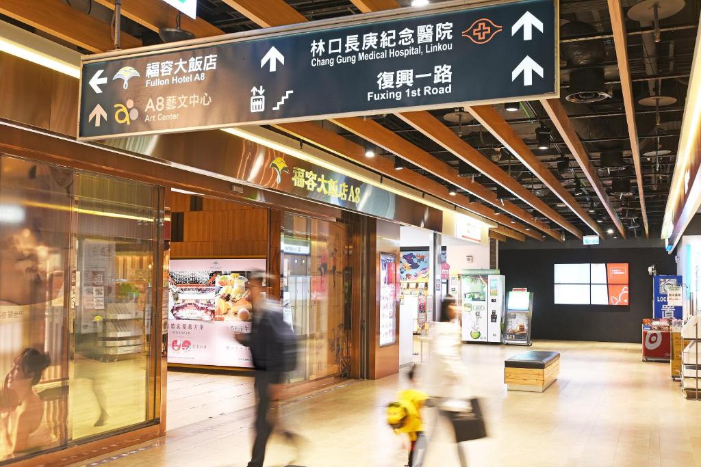 a person walking past a store in a shopping mall at Fullon Hotel Taoyuan Airport Access MRT A8 in Guishan