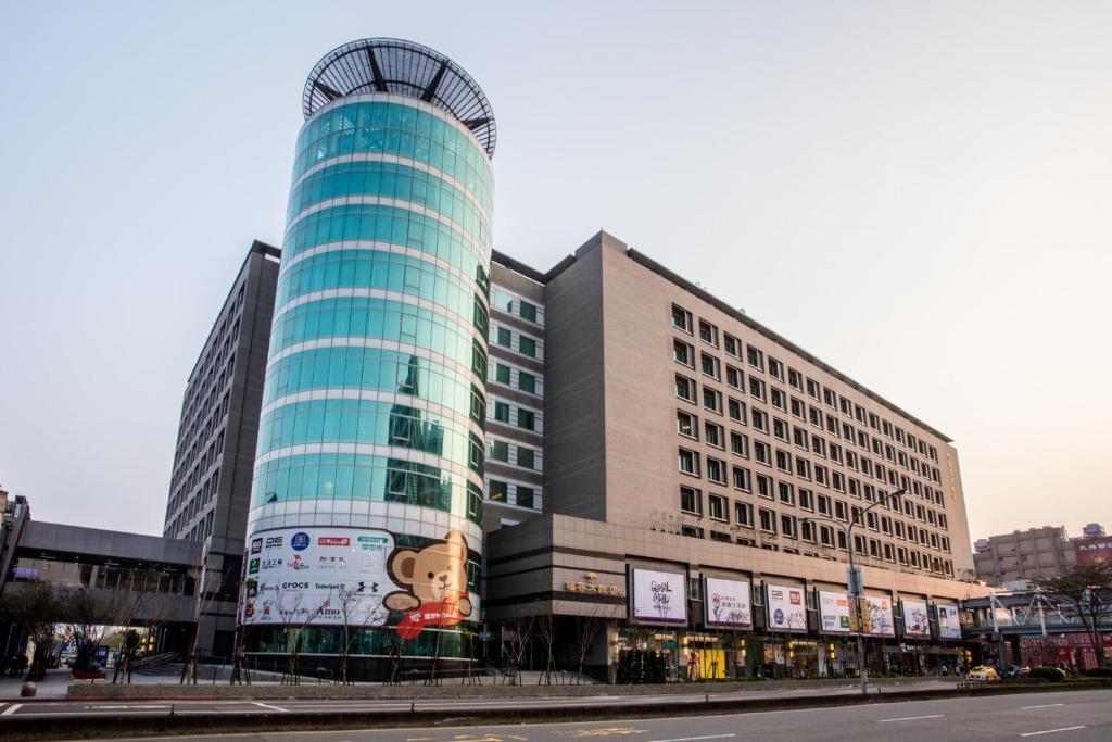 un edificio di vetro alto con un cartello sopra di Fullon Hotel Taoyuan Airport Access MRT A8 a Guishan