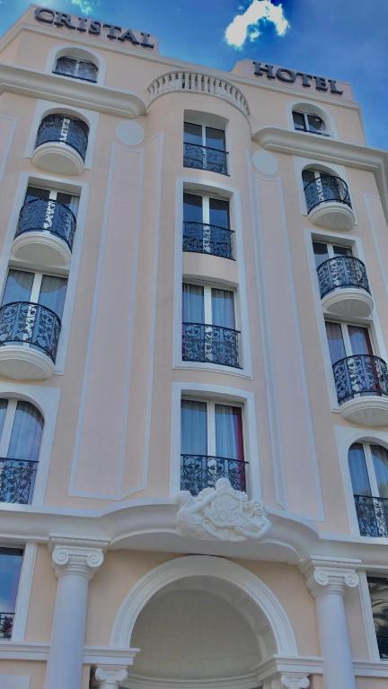 a tall white building with balconies on top of it at Cristal Hôtel & Spa in Cannes