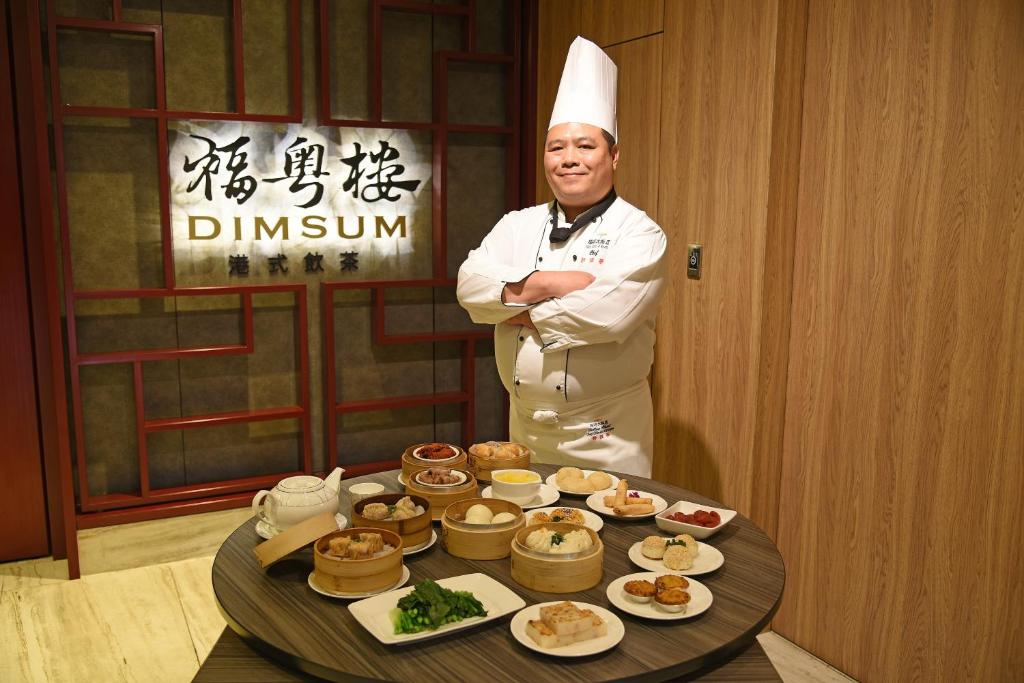 a chef standing in front of a table of food at Fullon Hotel Taoyuan Airport Access MRT A8 in Guishan