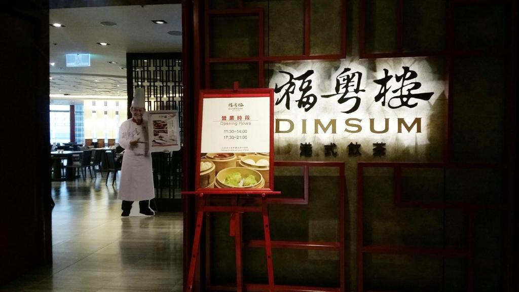 a woman standing next to a sign in a store at Fullon Hotel Taoyuan Airport Access MRT A8 in Guishan
